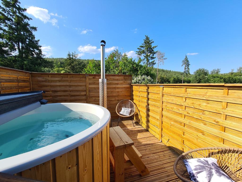 WeiterswillerGîte Le Bijou et Spa的甲板上的热水浴池,配有木栅栏