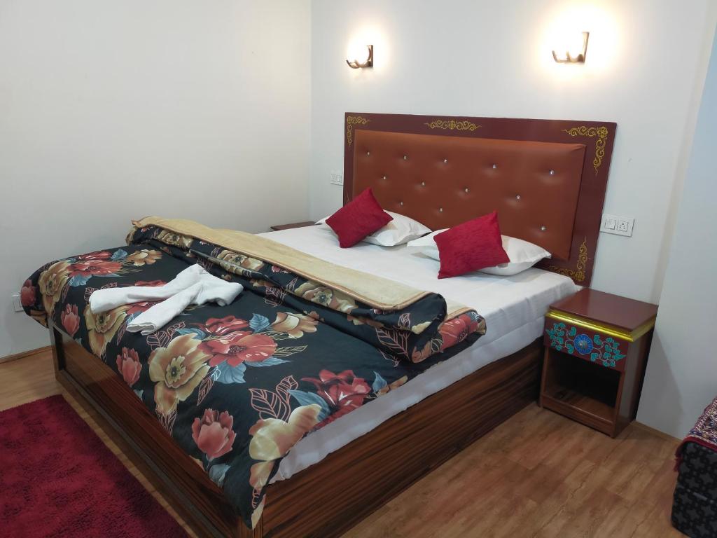 拉瓦格拉Sikkimese Inn的一间卧室配有一张带花卉床罩的床
