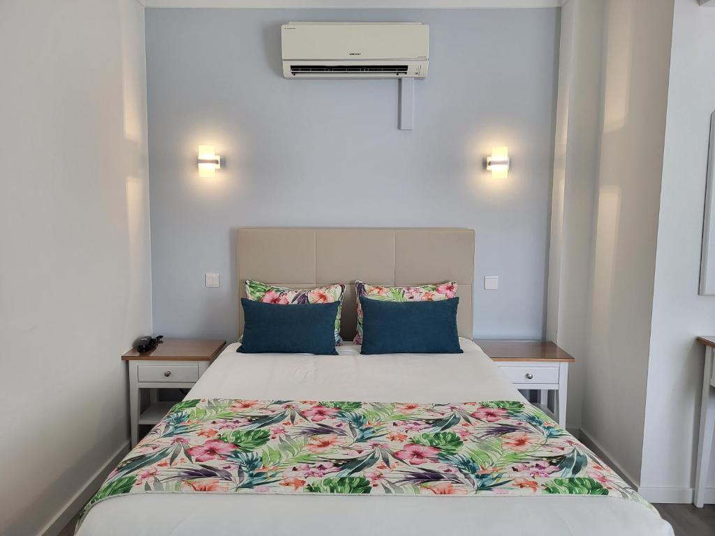 纳扎雷安可瑞月酒店的一间卧室配有一张带蓝色枕头的大床