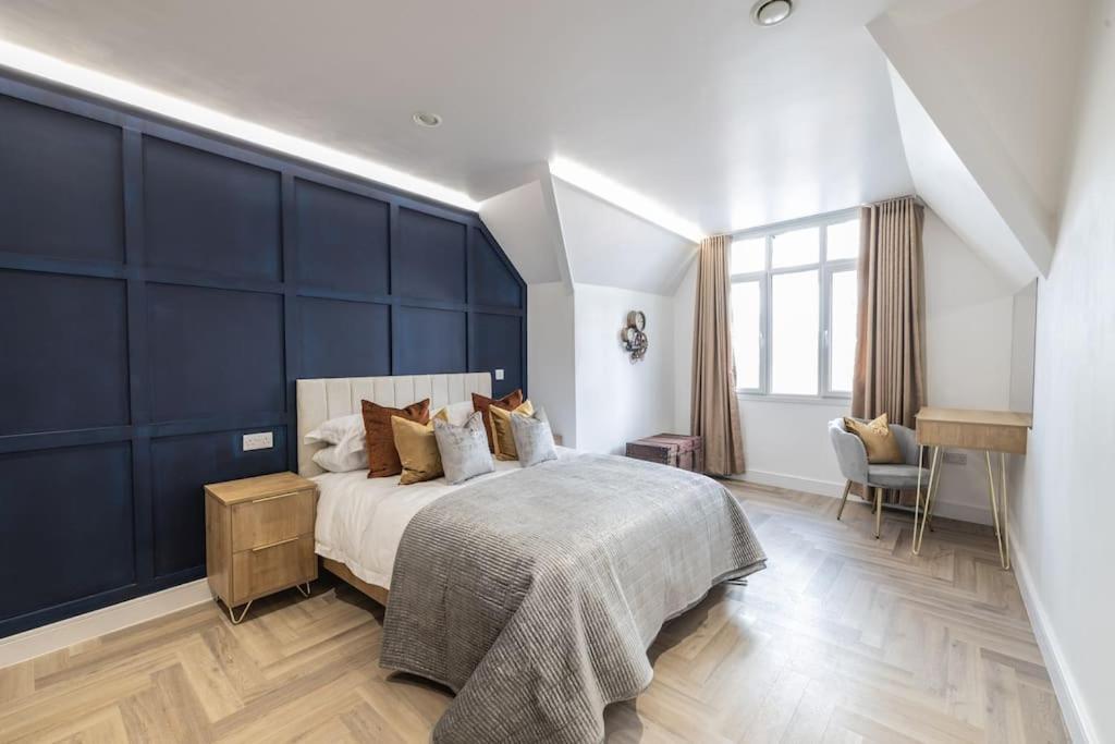莱斯特The Pocklington - The Magistrates Suite的一间卧室设有一张蓝色墙壁的大床