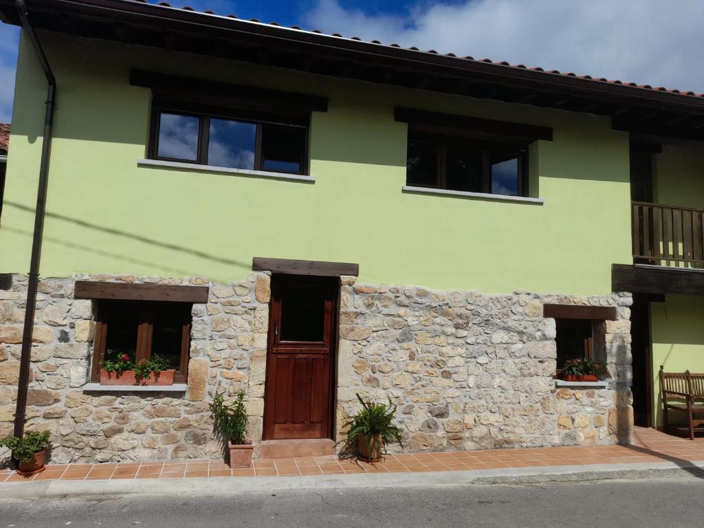 坎加斯-德奥尼斯La Posada del Canario的一座带石墙的绿色房子