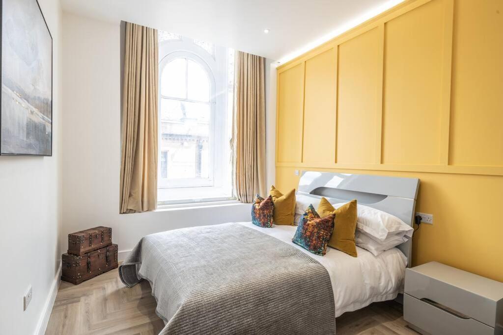 莱斯特The Pocklington - The Bradgate Suite的一间卧室设有一张黄色墙壁和窗户的床