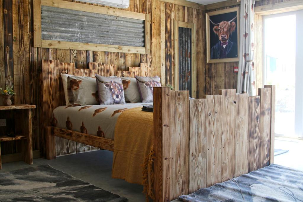 阿博伦The Moo-tel at Bargoed Farm的一间卧室配有一张木墙床