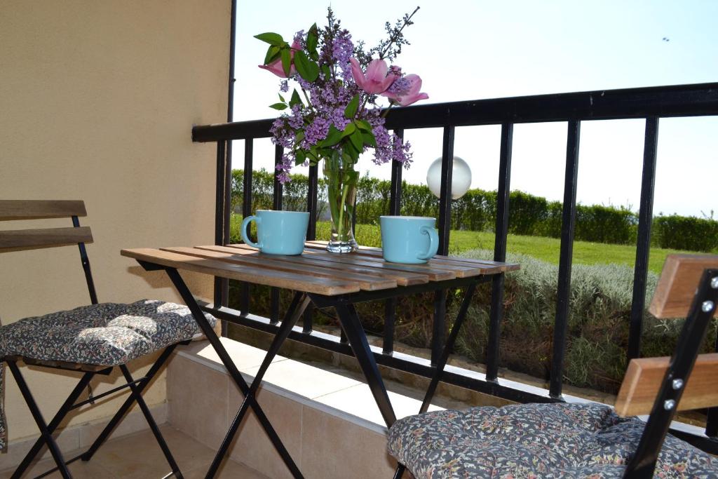 卡姆基亚Апартамент в Oasis beach Kamchia - Стъпки в пясъка的阳台上的花瓶桌子
