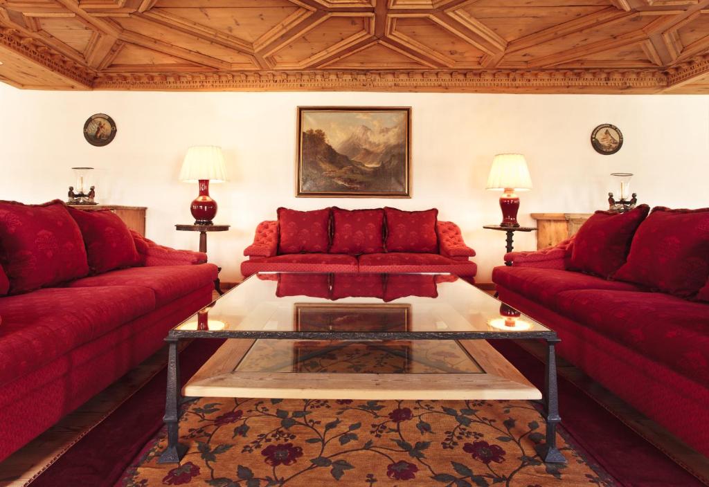 圣莫里茨顶级世界公寓 的客厅配有红色的沙发和桌子