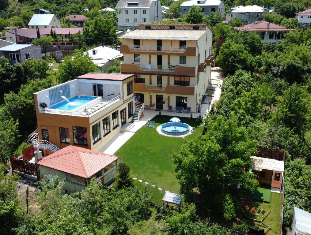 SuramiHotel Legiandro Surami的享有带游泳池的房屋的空中景致