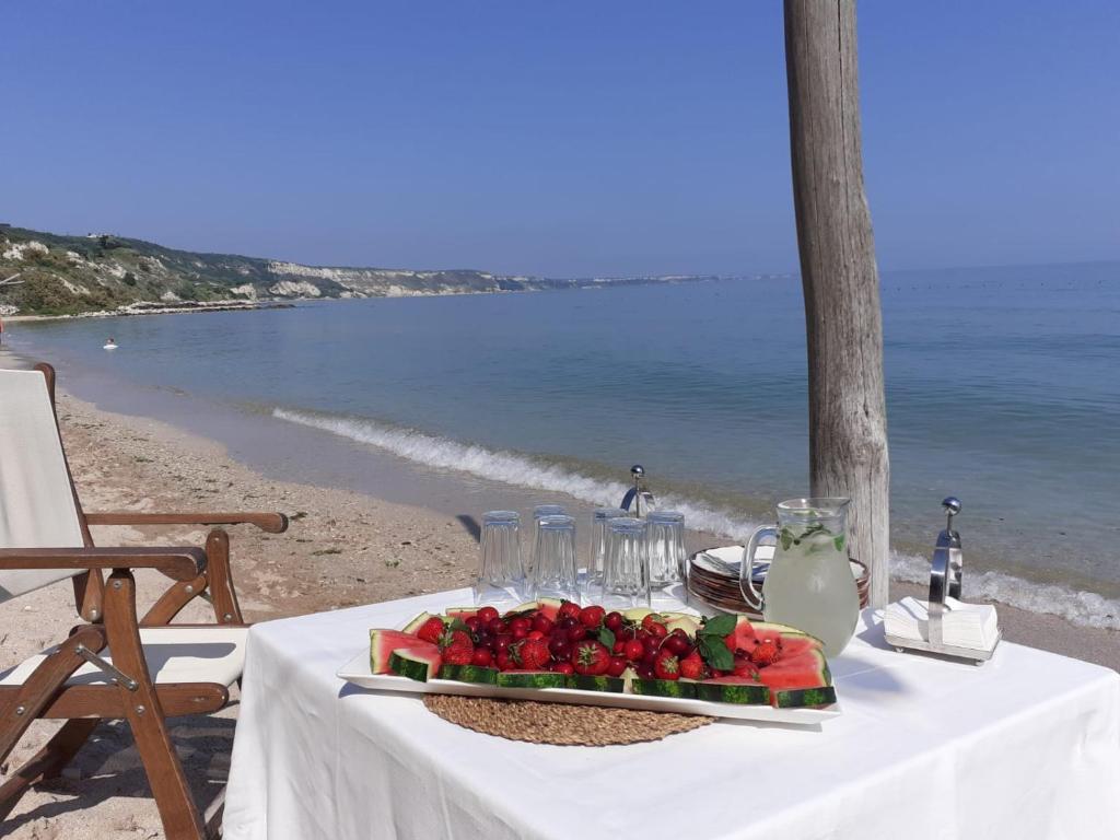 卡瓦尔纳Thracian cliffs Апартамент Голф холидей的一张桌子,上面有一盘水果在沙滩上