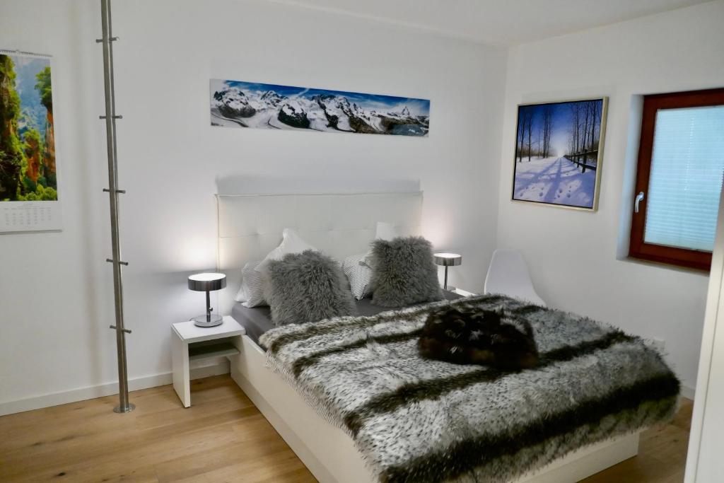 柏林42up Berlin Pankow的白色卧室配有一张带毛绒毯子的床