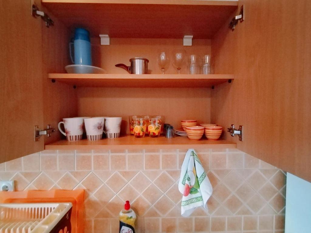 尤塔哈Apartmani LJUBICA的厨房配有带碗和餐具的柜台。