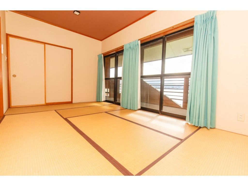大石Lake Kawaguchi Rental Villa Tozawa Center - Vacation STAY 46845v的一间空房间,设有大窗户