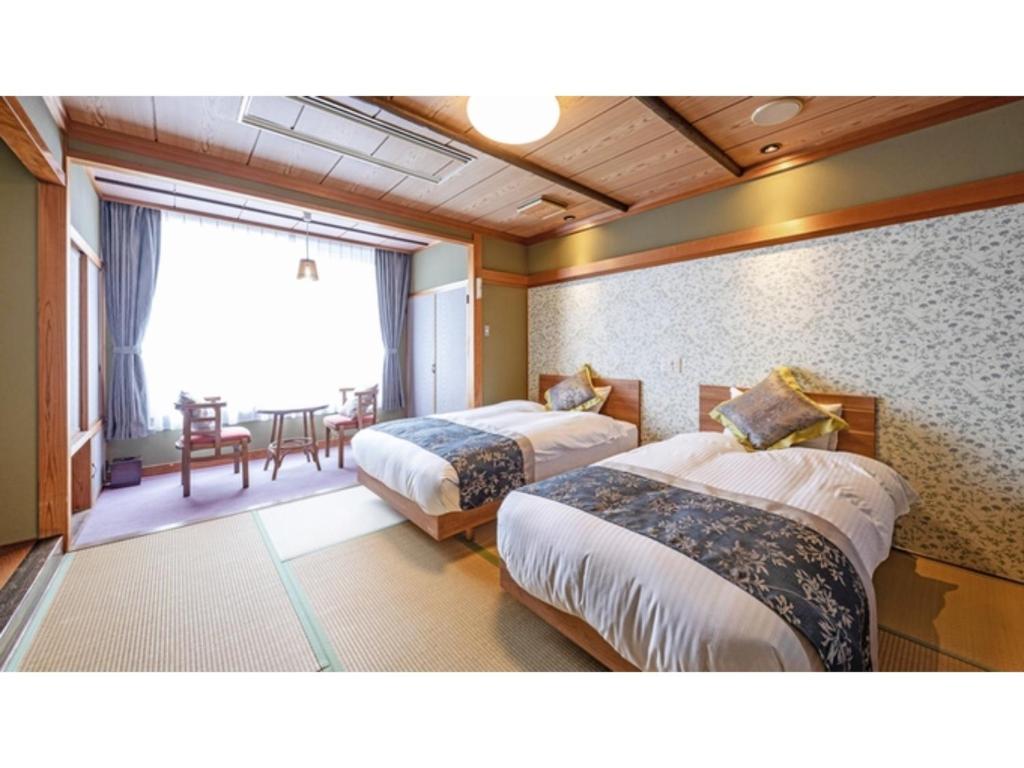 新发田市Tsukioka Onsen Furinya - Vacation STAY 55991v的一间酒店客房,设有两张床和一间餐厅