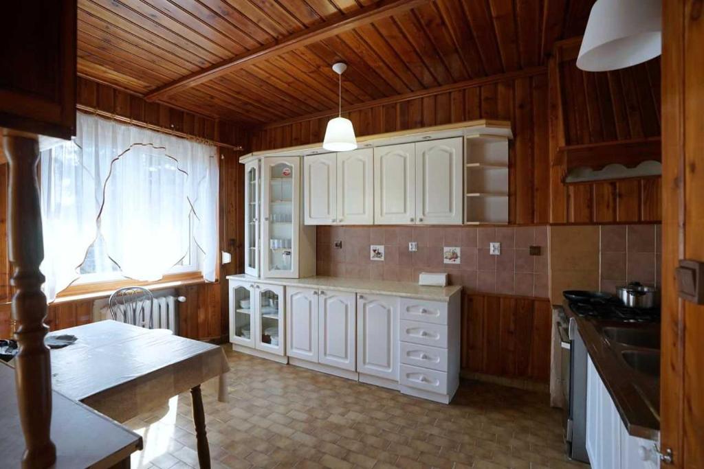 什切青Hostel na Anhellego的厨房配有白色橱柜和木制天花板