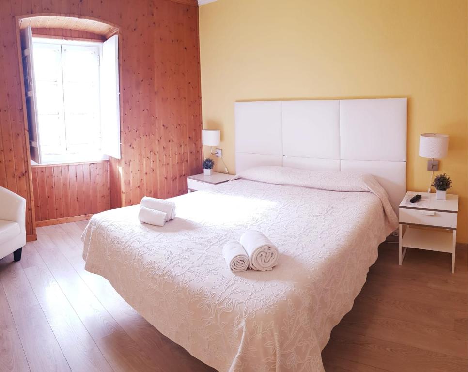 埃尔瓦斯Alcamim Guesthouse的一间卧室配有一张大床和毛巾