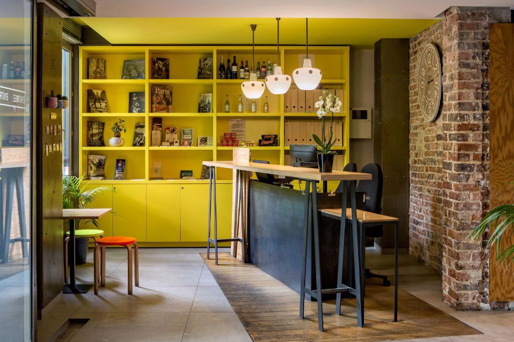 巴黎加斯顿酒店的厨房配有黄色橱柜和桌子