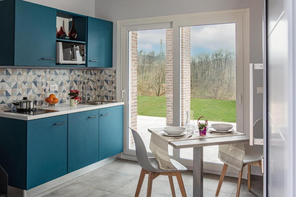 卡伊罗蒙泰诺泰Ca' Brichella的厨房配有蓝色橱柜和桌椅