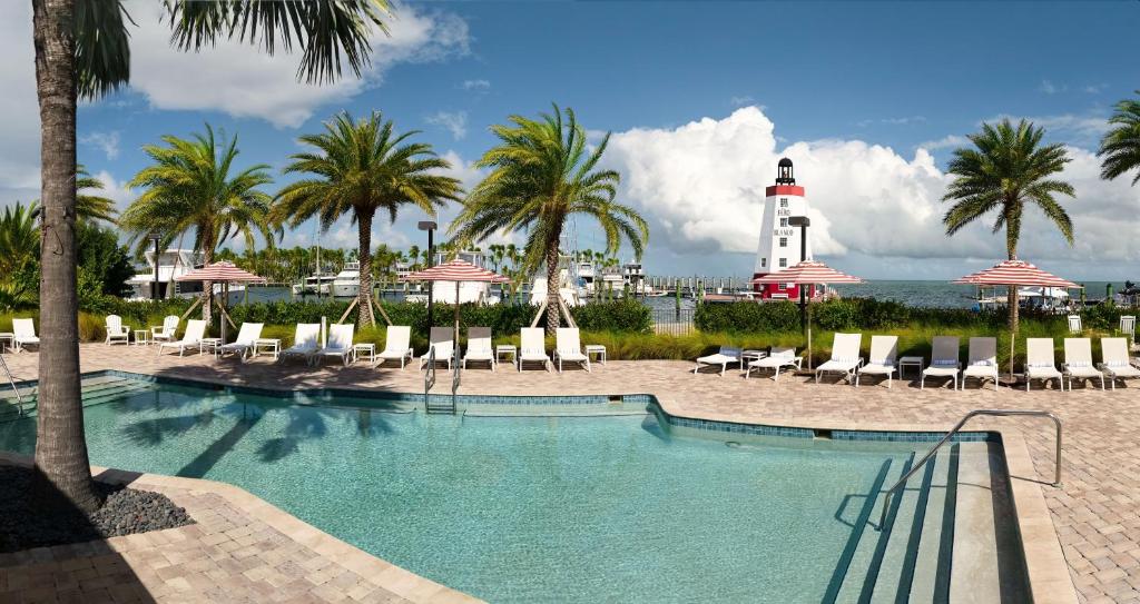 马拉松Faro Blanco Resort & Yacht Club的一个带椅子的游泳池和一个位于后面的灯塔