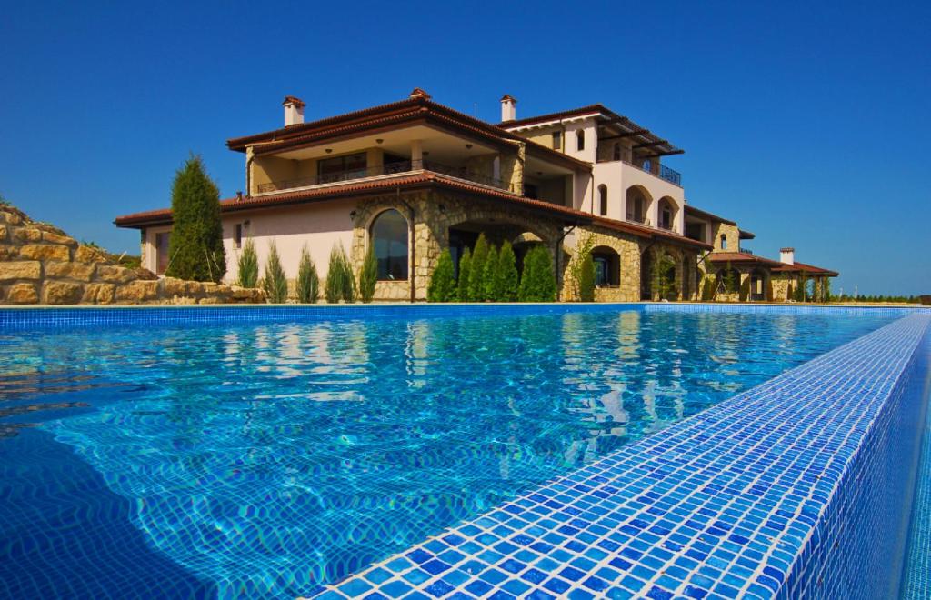 巴尔奇克黑海拉马高尔夫俱乐部公寓酒店的一座房子前面设有游泳池