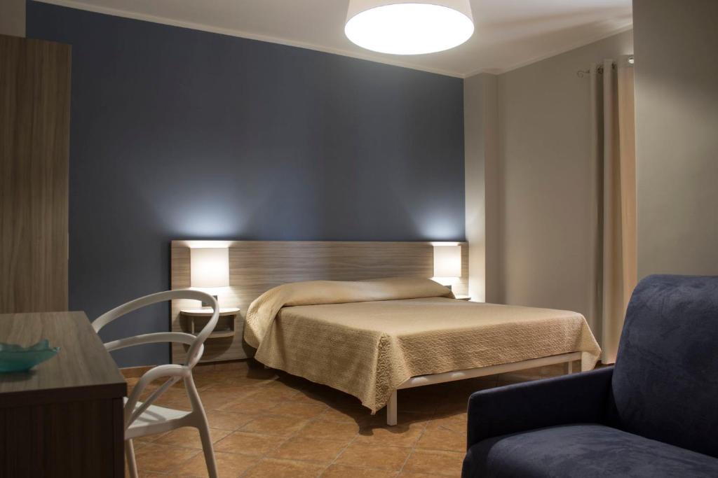 兰佩杜萨Incanto Luxury Rooms的一间卧室配有一张床、一把椅子和一张沙发