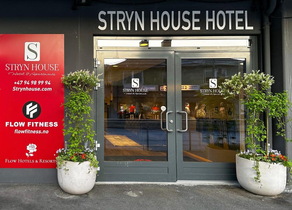 史特林Stryn House - Hotel & Apartments的门前有两株盆栽植物的商店