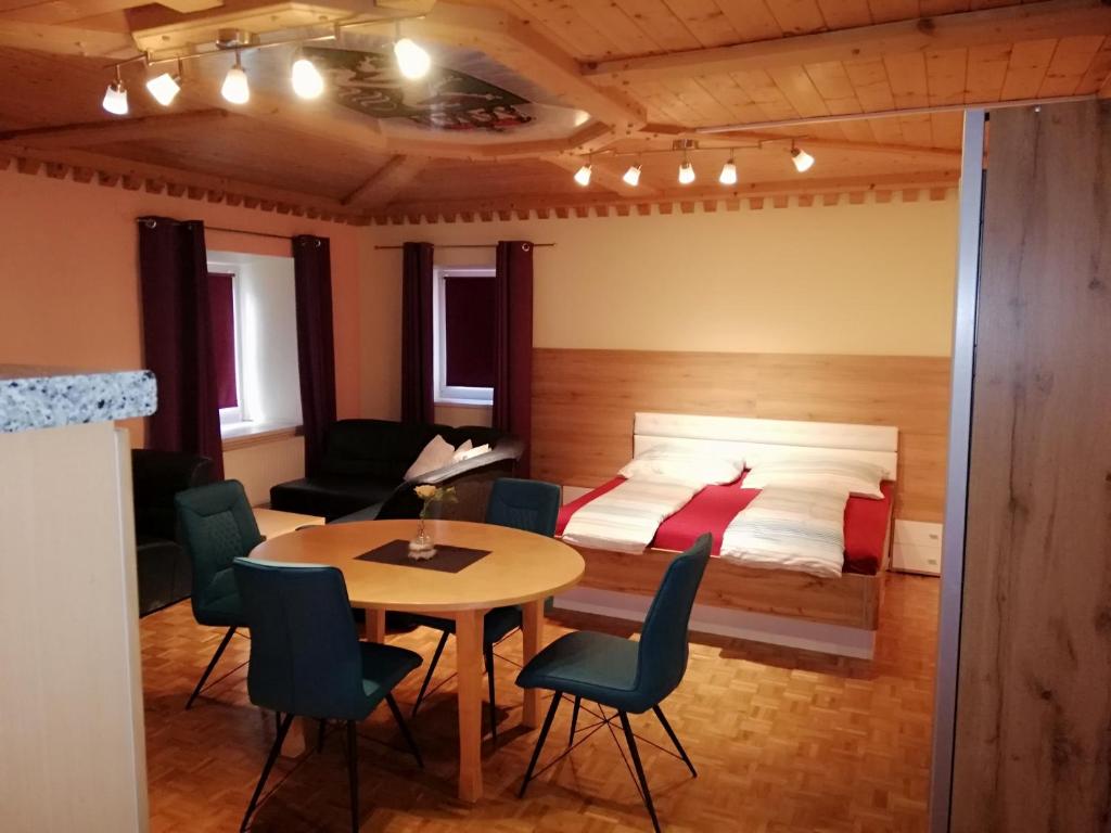 Sankt Peter am KammersbergZimmer und Appartement Marktcafe Sankt Peter am Kammersberg 87的卧室配有一张床和一张桌子及椅子