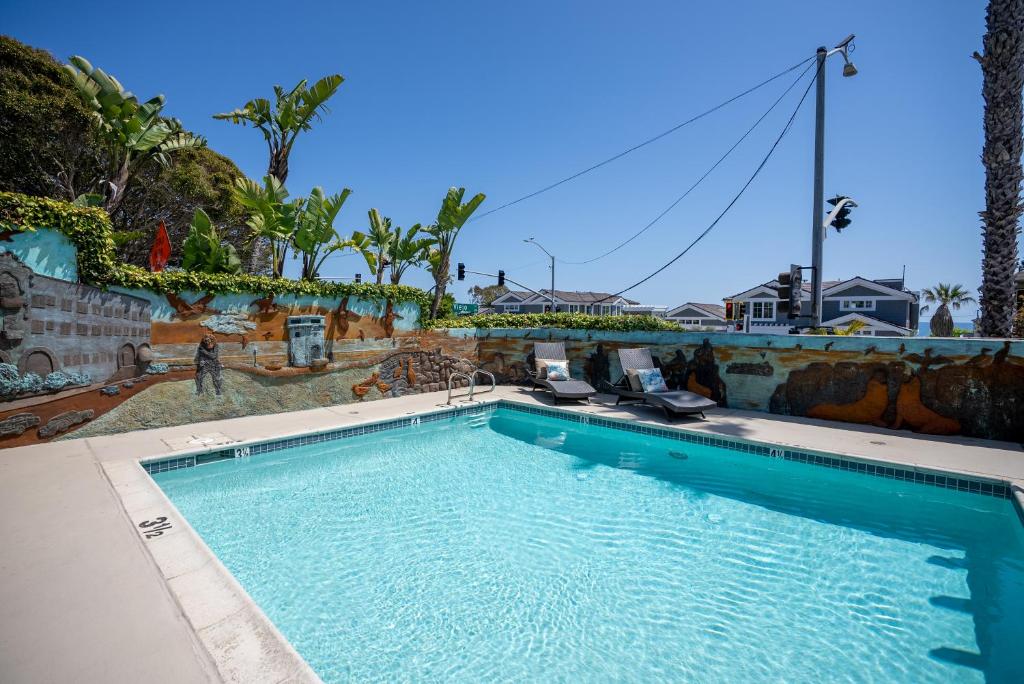 拉古纳海滩Art Hotel Laguna Beach的房屋前设有带2把躺椅的大型游泳池