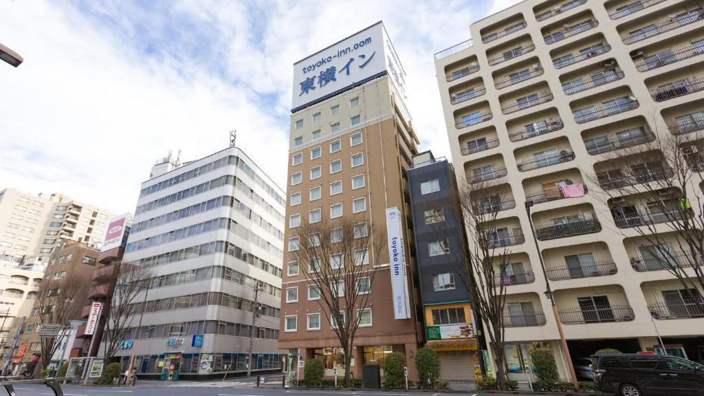 东京Toyoko Inn Tokyo Nihombashi Hamacho Meijiza Mae的一座高大的建筑,上面有标志