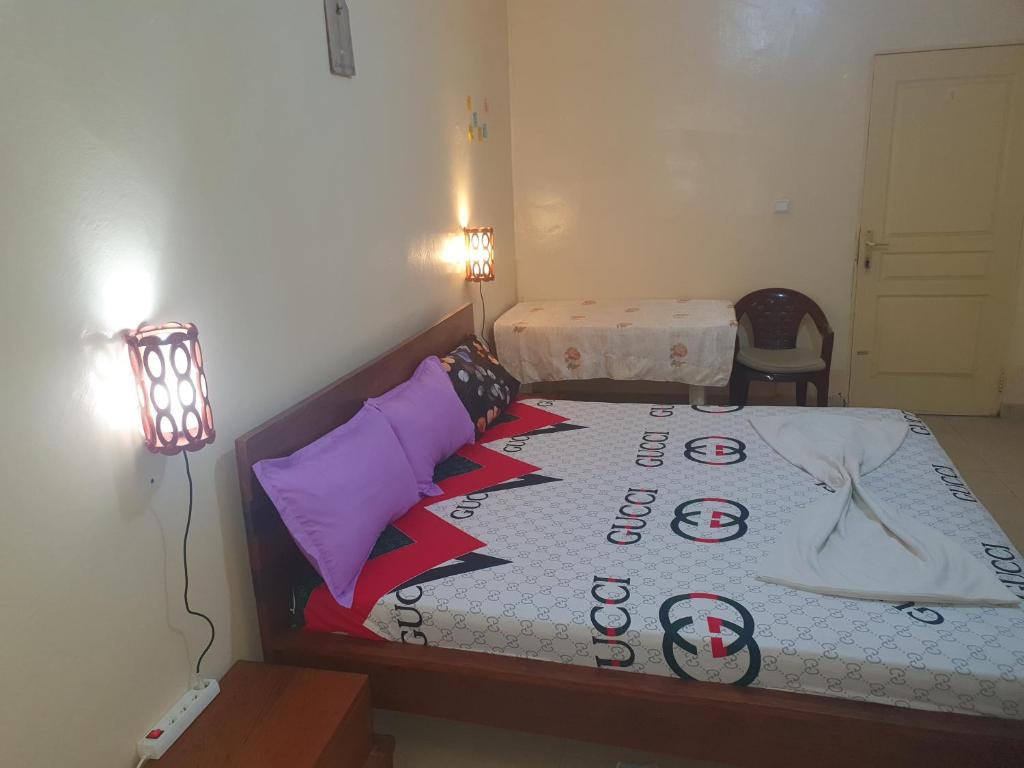 达喀尔JADO House的一间卧室,配有一张带标志的床