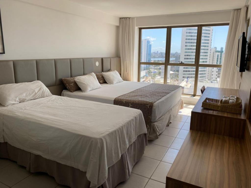累西腓BEIRA MAR- FLAT EXECUTIVE的酒店客房设有两张床和大窗户。