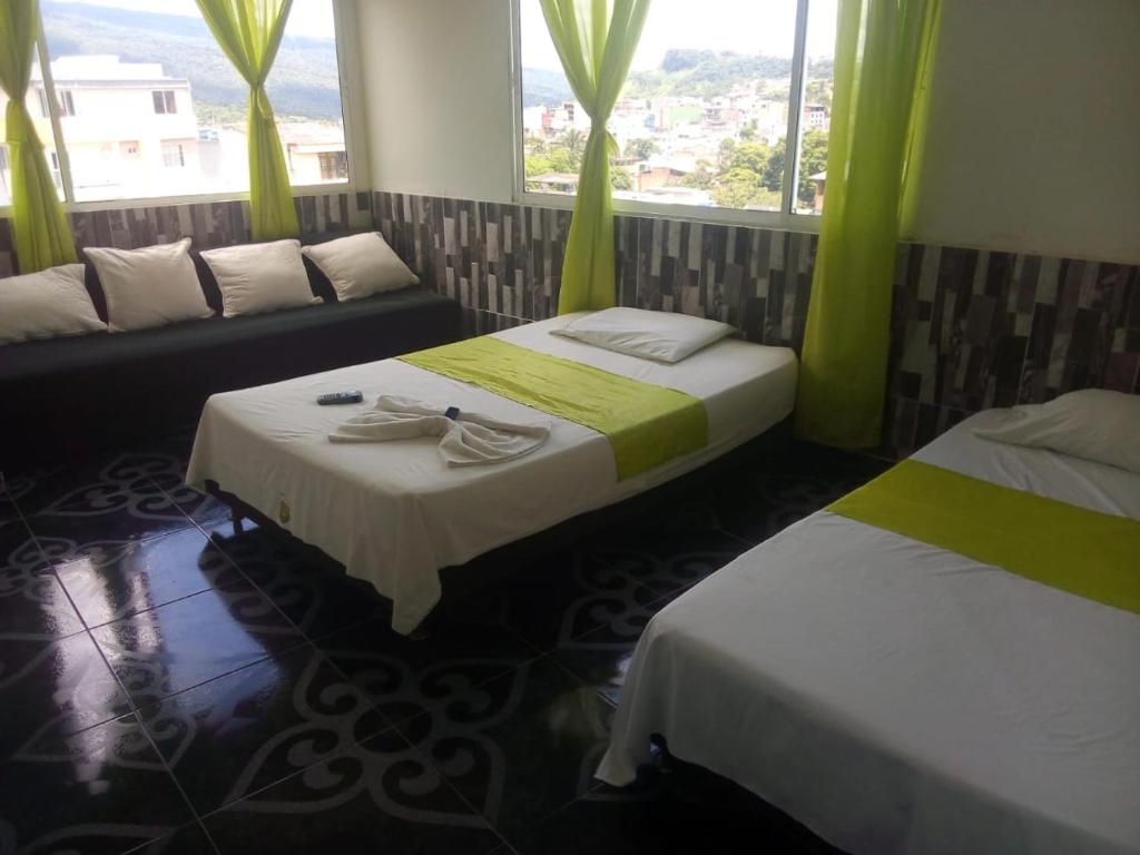 莫科阿Hotel Luis Ángel的客房设有两张床、一张沙发和窗户。
