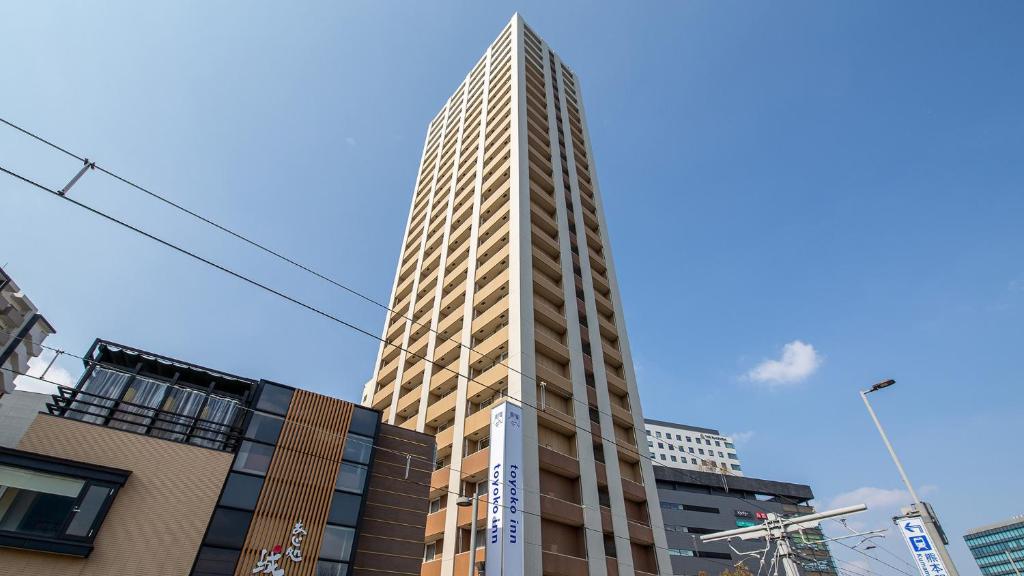 熊本Toyoko Inn Kumamoto Ekimae的城市中心高耸的摩天大楼