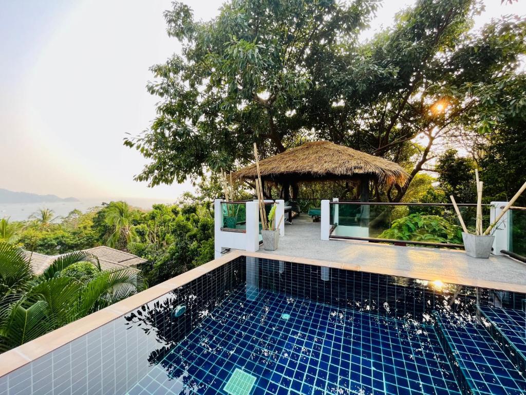 涛岛Banana Villa Koh Tao的享有带小屋的游泳池的景色