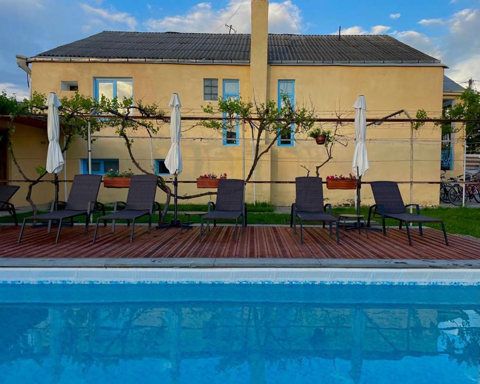 阿斯平贾Brewery House&Beer Spa的一组椅子和遮阳伞,位于游泳池旁