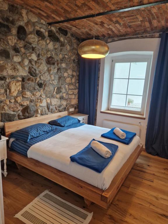 拉多夫吉卡Sobe Lotrist的卧室配有一张石墙内的大床