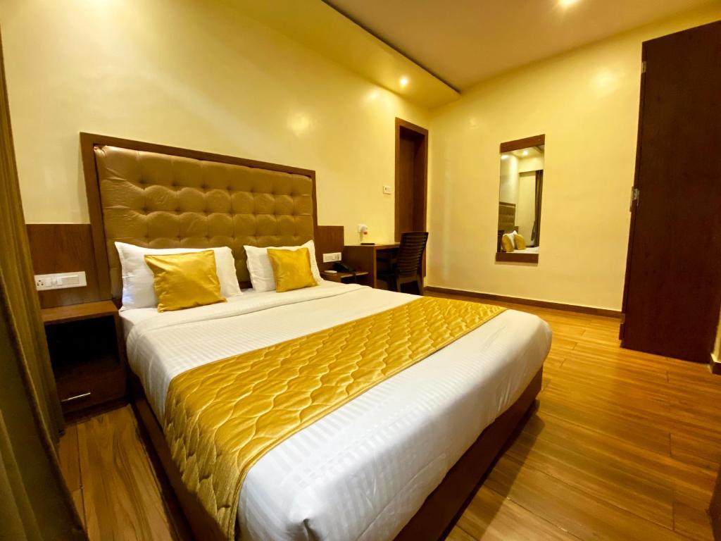 孟买Hotel Pearl's BKC Inn- Near Trade Centre, Visa Consulate的酒店客房配有一张带黄色枕头的大床