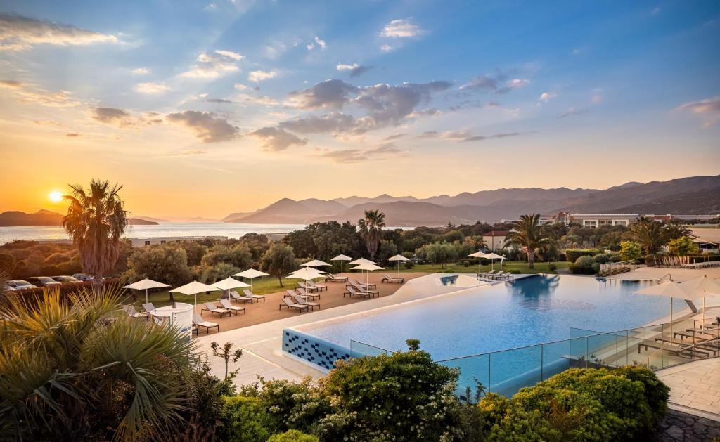 杜布罗夫尼克Valamar Lacroma Dubrovnik Hotel的享有日落的度假村游泳池景致
