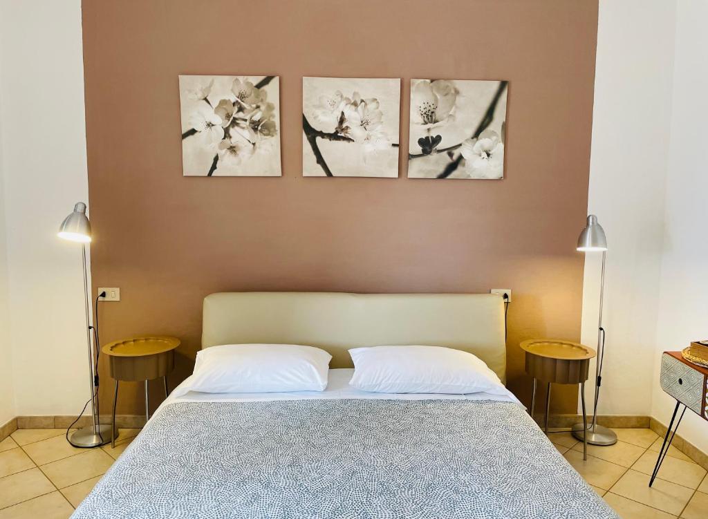 瑟克罗B&B L'albero di Melograno的卧室配有一张四幅画的墙壁床。