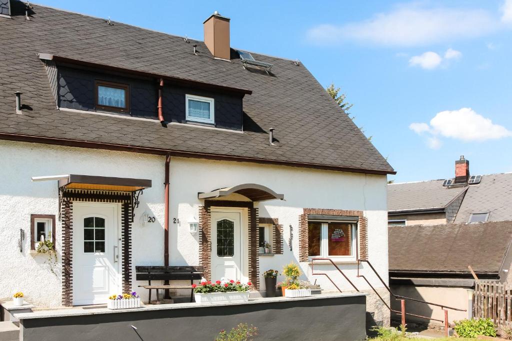 Ferienwohnung am Sachsenring的黑色屋顶的白色房子