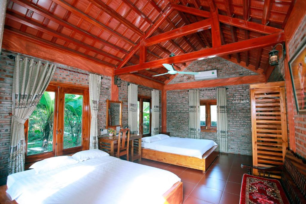 宁平Ninh Binh Mountain View Homestay & Restaurant的一间卧室设有两张床和砖墙