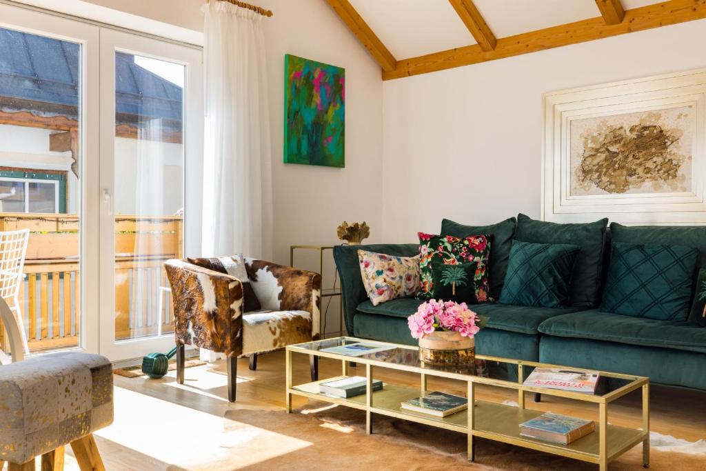 圣沃尔夫冈Pfamhaus Penthouse的客厅配有绿色沙发和椅子