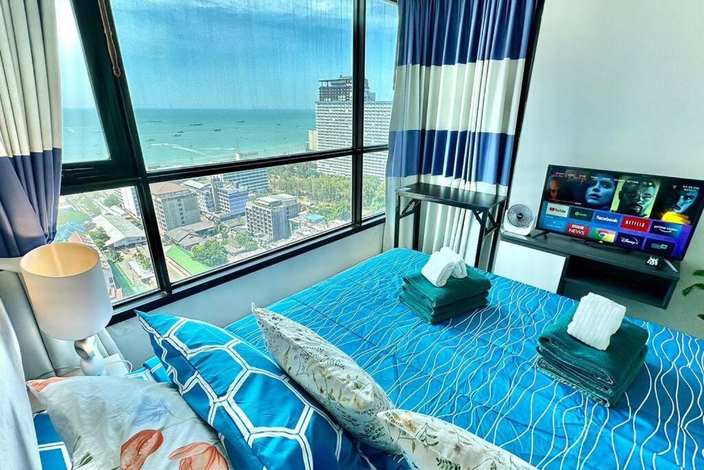 芭堤雅市中心The BASE Central PATTAYA 2Bed on Sky的一间享有海景的卧室,配有一张蓝色的床