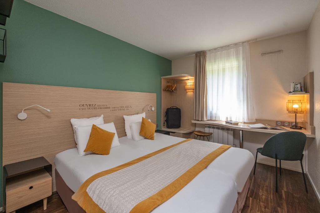 布隆基里亚德里昂东布隆厄尔波科塔奇酒店的酒店客房设有一张大床和一张书桌。