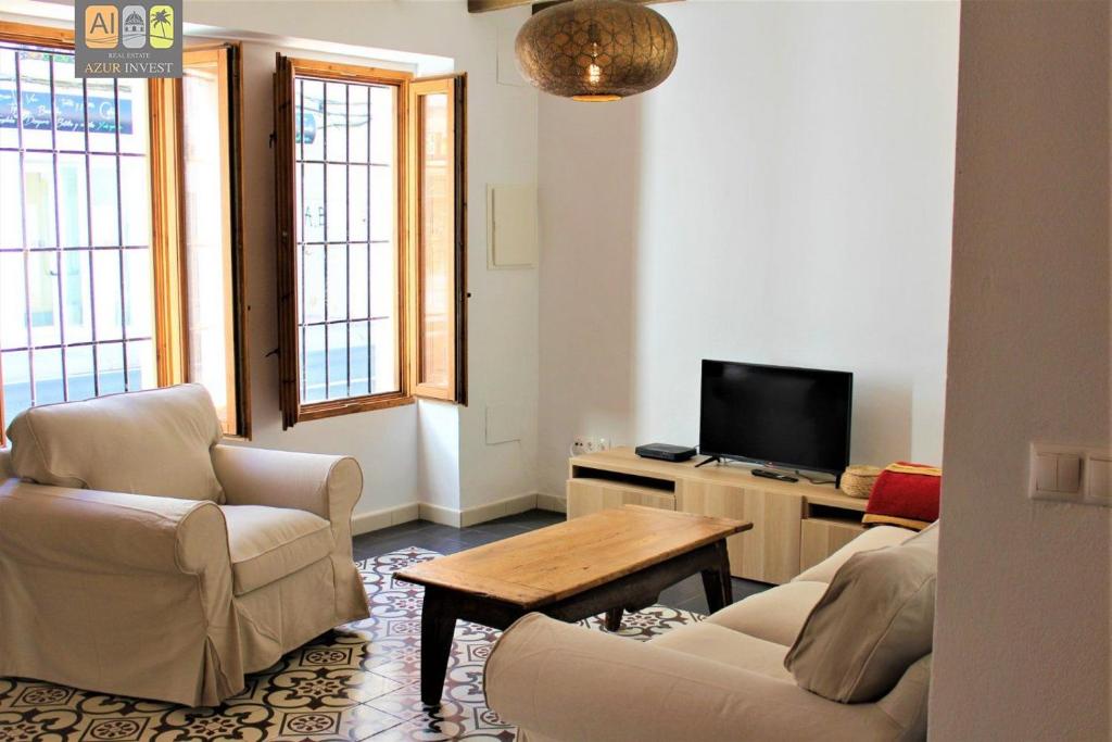 阿尔啼Casa Violeta的客厅配有两把椅子、一张桌子和一台电视