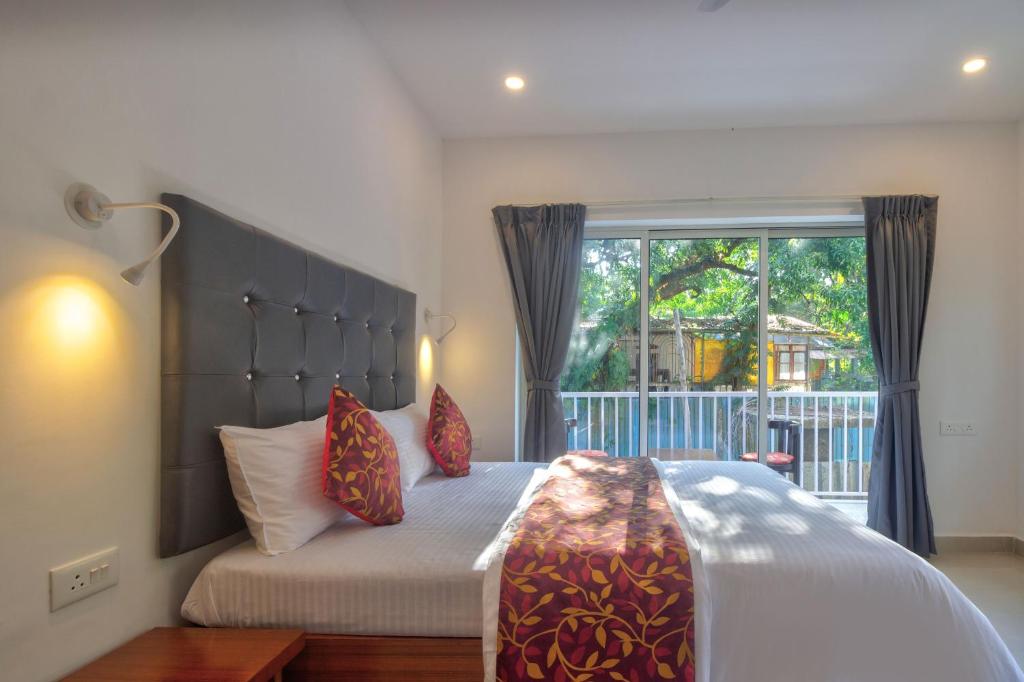 巴加Amazing 2BHK Apartment Near Baga Beach By Stay Over Home的一间卧室设有一张大床和大窗户