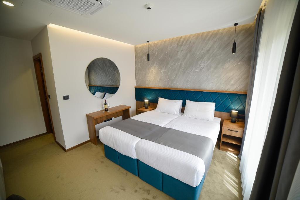 兹拉蒂博尔Lakeside的一间卧室配有一张大床和蓝色床头板