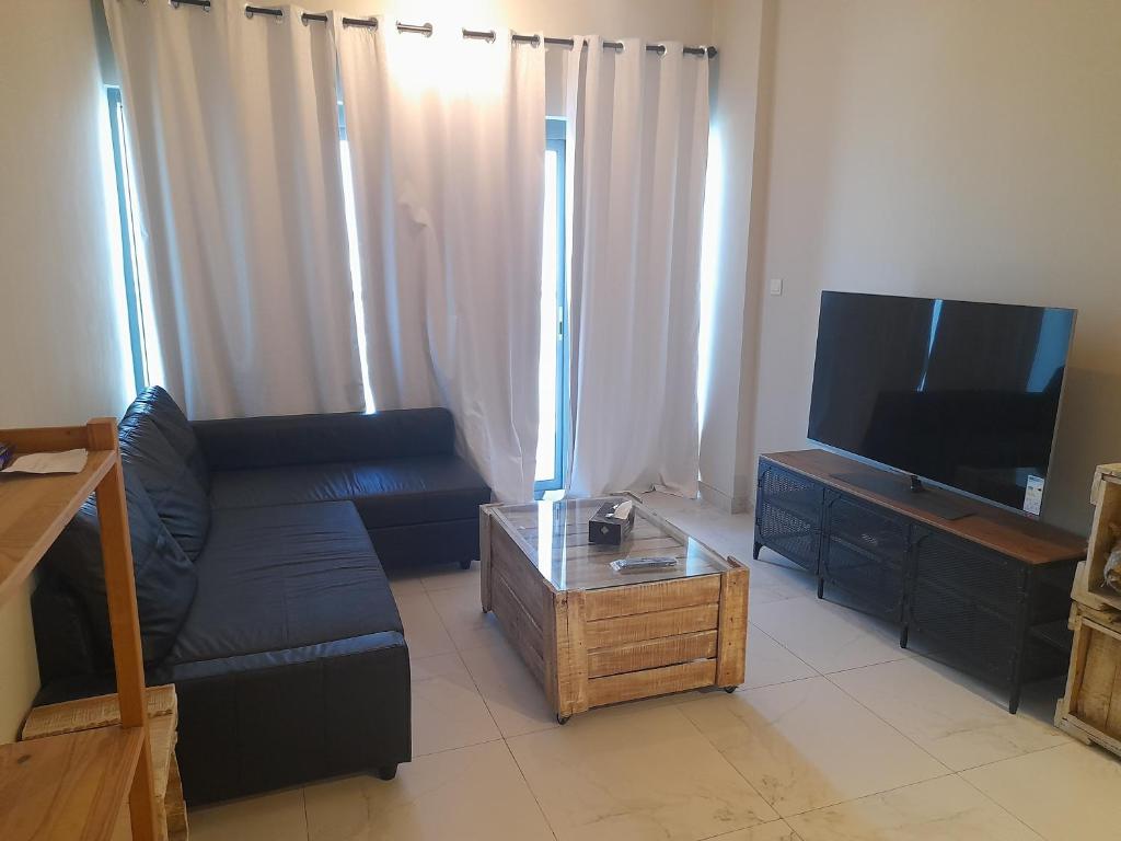 迪拜a chilled place的客厅配有黑色沙发和平面电视。