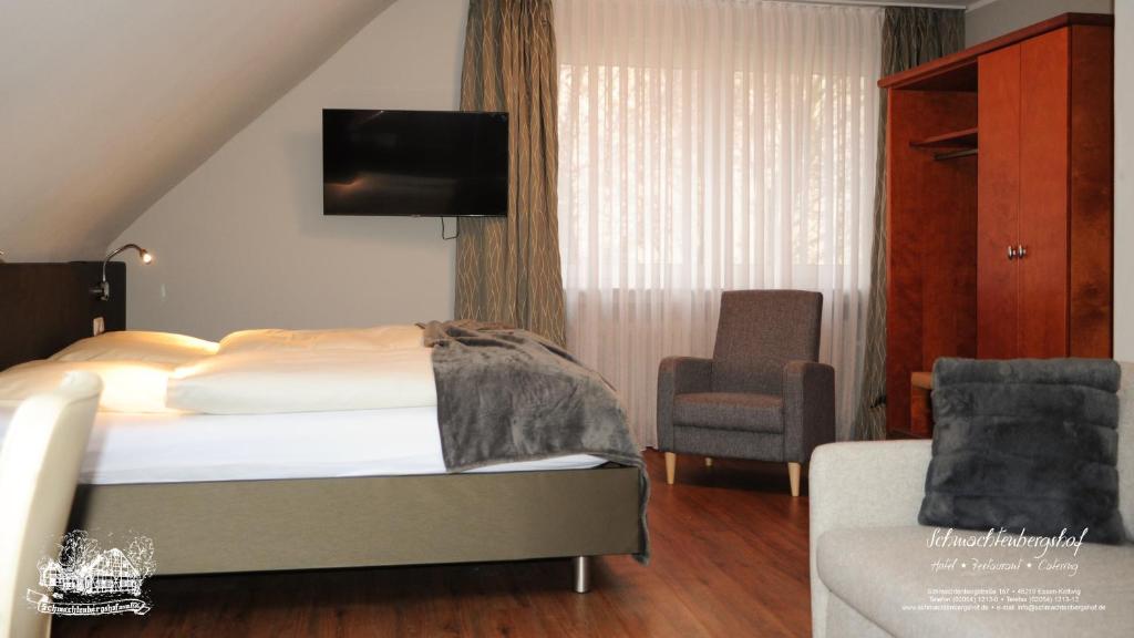 埃森施马丁堡硕餐厅酒店的配有一张床和一把椅子的酒店客房