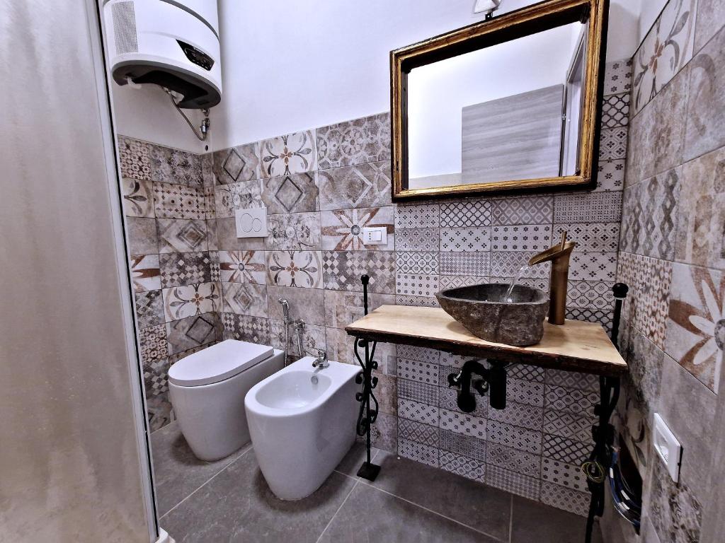 博洛尼亚La Ca' Pezzana Affittaly Apartments的一间带水槽、卫生间和镜子的浴室