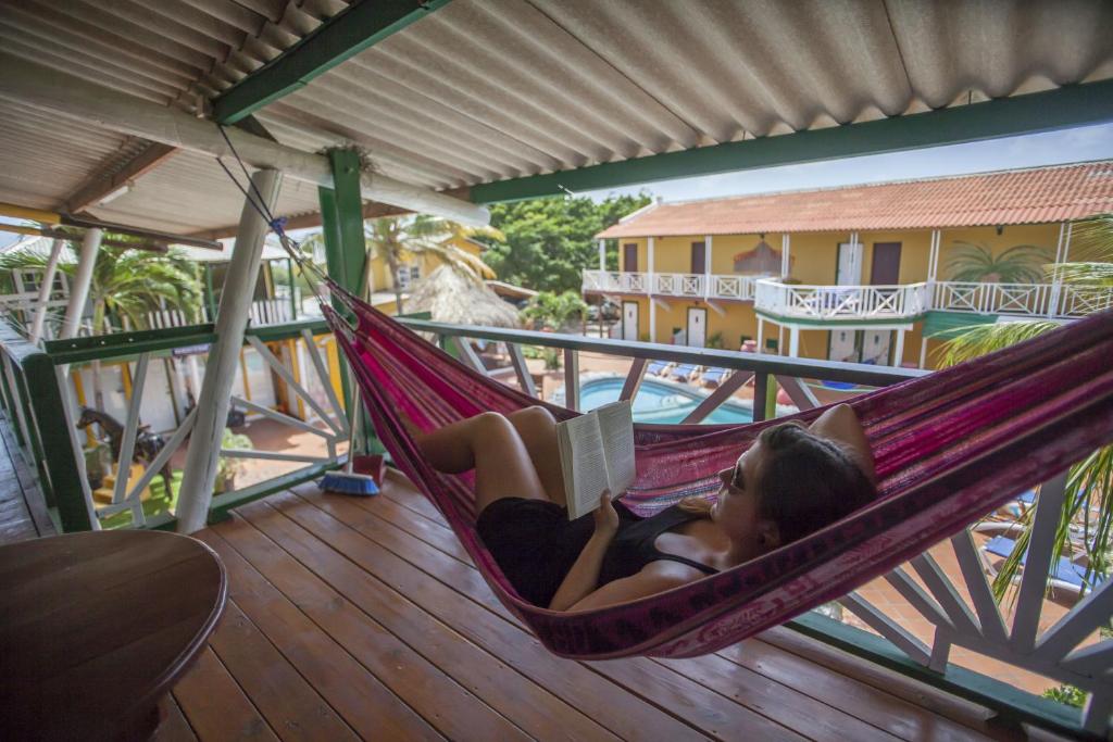 Sabana Westpunt蓝佐索布里诺酒店的躺在吊床上读书的女人