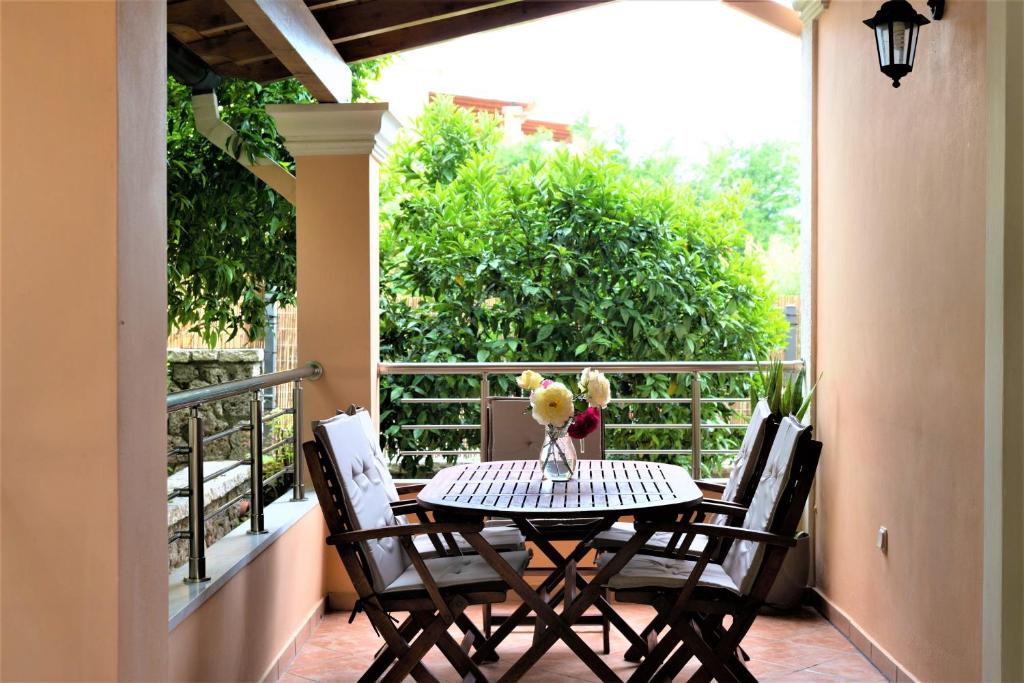 波塔莫斯La Bella Vita - Luxury Holiday House close to Corfu Town的阳台配有桌椅和桌子