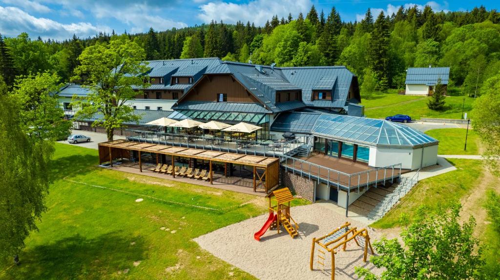 德尔内夫奥里克Amenity Hotel & Resort Orlické hory的享有带游乐场的房屋的空中景致